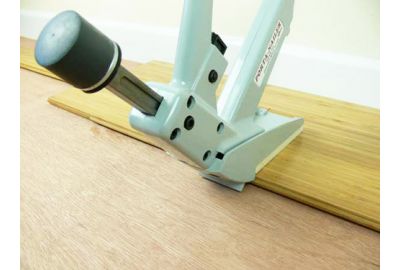 Installing bamboo flooring with secret nail gun onto joists