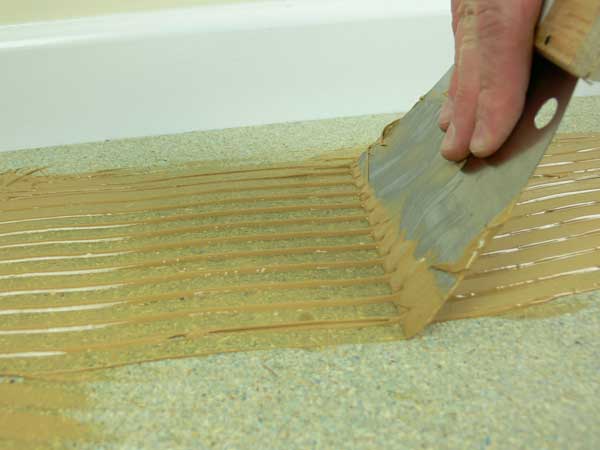 Flooring adhesive being applied onto a sub floor